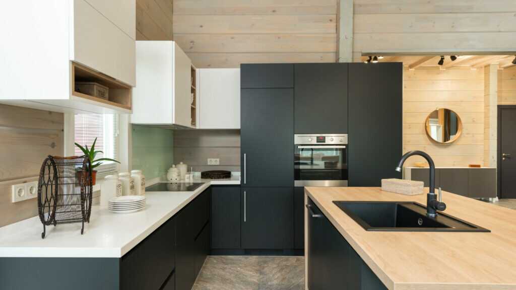 Moderne Küche mit matter, weißer Arbeitsplatte im Dekor FENIX Bianco Kos und natürlichen Holzfronten.