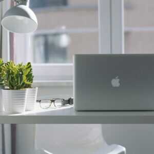 Weißer Tisch im Büro mit Laptop und Pflanzen