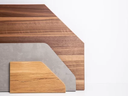 Drei Holzplatten-Zuschnitte in Sonderformen mit abgeschrägten Ecken in verschiedenen Dekoren vor weißem Hintergrund.