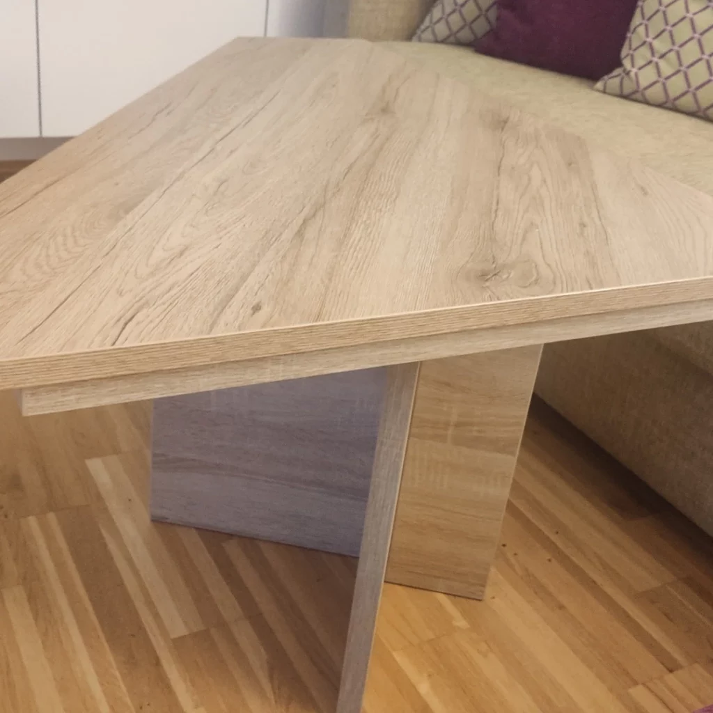 Runder Gartentisch mit dunkler HPL Tischplatte auf einer Terrasse neben einem Terrakotta-Ofen und Zitronenbaum im Hintergrund.